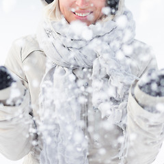 Image showing Girl  playing with snow in winter.