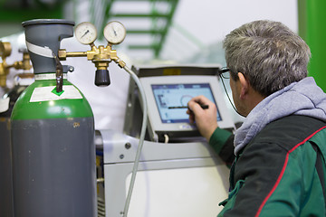 Image showing Industrial worker setting orbital welding machine.