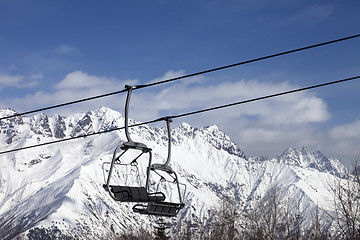 Image showing Chair lift in snowy mountains at nice sunny day