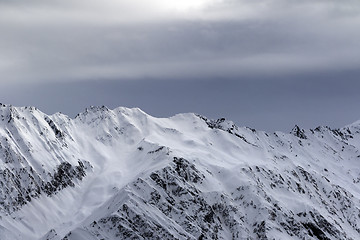 Image showing High snowy mountains and sunlight storm sky before blizzard