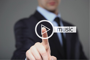 Image showing Businessman pressing play music button 