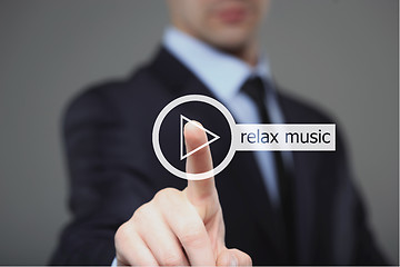 Image showing Businessman pressing play relax music button 