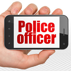Image showing Law concept: Hand Holding Smartphone with Police Officer on display