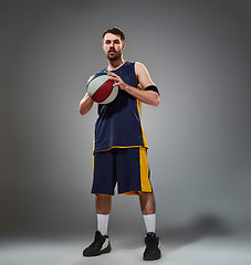 Image showing Full length portrait of a basketball player posing with ball 