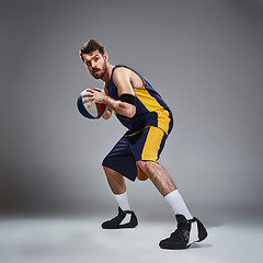 Image showing Full length portrait of a basketball player posing with ball 