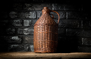 Image showing Wicker bottle in cellar