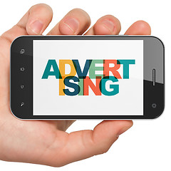 Image showing Marketing concept: Hand Holding Smartphone with Advertising on  display