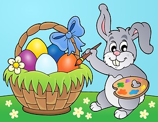 Image showing Bunny painting eggs in basket
