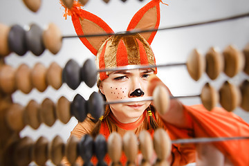 Image showing Young woman in the image of red squirrel with abacus 