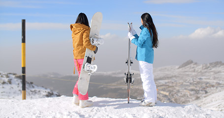 Image showing Two women snowboarders enjoying the winter view