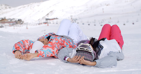 Image showing Two skiers laying on the ground