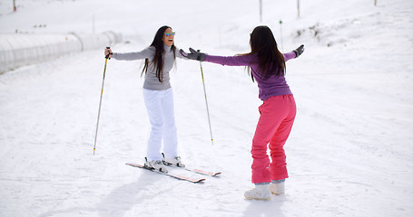 Image showing Young woman teaching her friend to ski