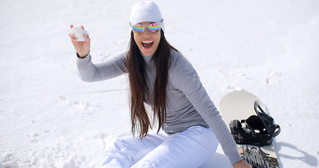 Image showing Playful young woman throwing a snowball