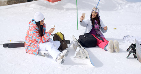 Image showing Young female friends relaxing with snowboards