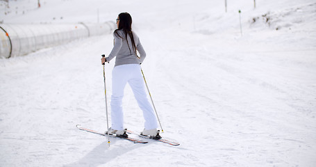 Image showing Cute woman on skis at bottom of hill