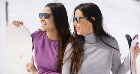 Image showing Two attractive young women with their snowboards