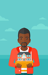 Image showing Man holding house model.
