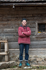 Image showing young hipster in front of wooden house