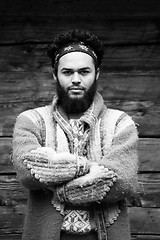 Image showing portrait of young hipster in front of wooden house