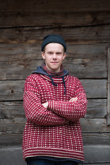 Image showing young hipster in front of wooden house