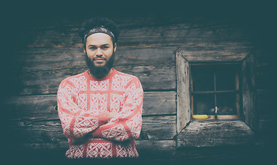 Image showing portrait of young hipster in front of wooden house