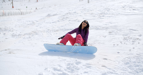 Image showing Laughing snowboarder falls in the snow