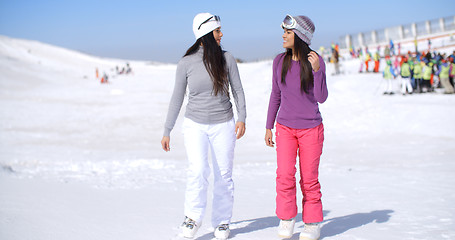 Image showing Two attractive young woman walking in fresh snow