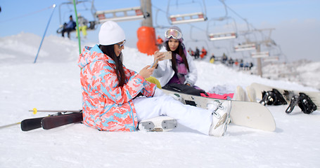 Image showing Two attractive female snowboarders