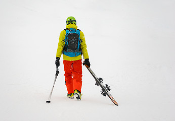 Image showing Sad and weary skier goes away, dragging skis.