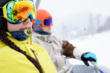 Image showing Couple sitting on chairlift in mountain resorts.