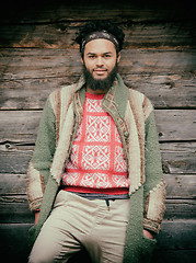 Image showing portrait of young hipster in front of wooden house