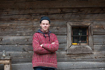 Image showing young hipster in front of wooden house