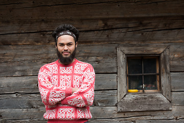 Image showing portrait of young hipster in front of wooden house