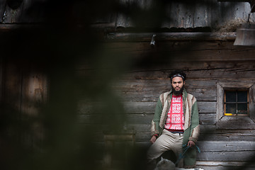 Image showing hipster with dog in front of wooden house