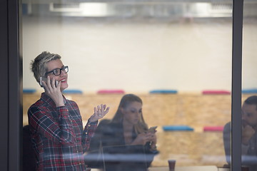 Image showing business woman in meeting room  speaking by cell phone