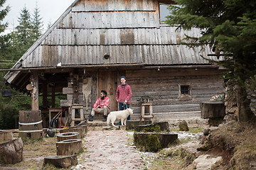 Image showing frineds together in front of old wooden house