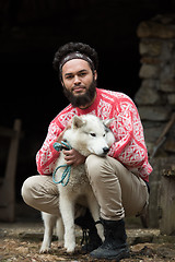 Image showing hipster with dog in front of wooden house