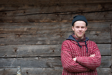 Image showing young hipster in front of wooden house