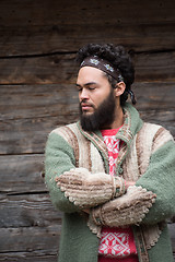 Image showing portrait of young hipster in front of wooden house