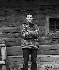 Image showing young hipster in front of wooden house