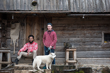 Image showing frineds together in front of old wooden house