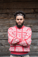 Image showing portrait of young hipster in front of wooden house