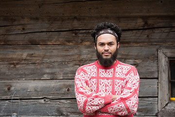 Image showing portrait of young hipster in front of wooden house