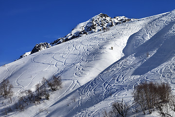 Image showing Off-piste slope with track from ski and snowboard on sunny day