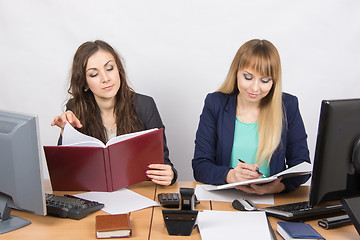 Image showing Two business women working in the office with one desk