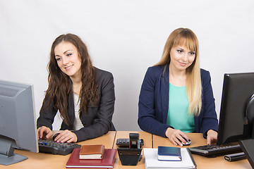 Image showing Two young girls working at the computer sitting at a table in the office