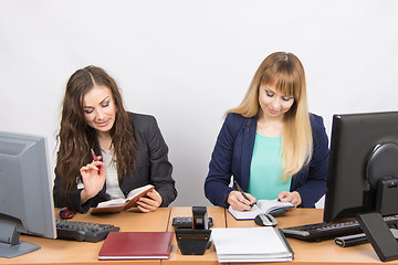 Image showing  Two business women looking at diaries and make a plan of the day