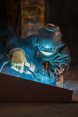 Image showing worker welding metal