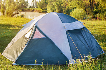 Image showing Private camping tent on the meadow near the river.