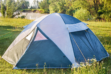 Image showing Private camping tent on the meadow near the river.